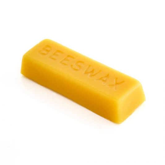 Eight blocks of raw beeswax in a cardboard box, with the box having a label indicating '100% Pure Natural Organic British Beeswax' and the brand 'Rhoose Point Remedies Ltd.'.