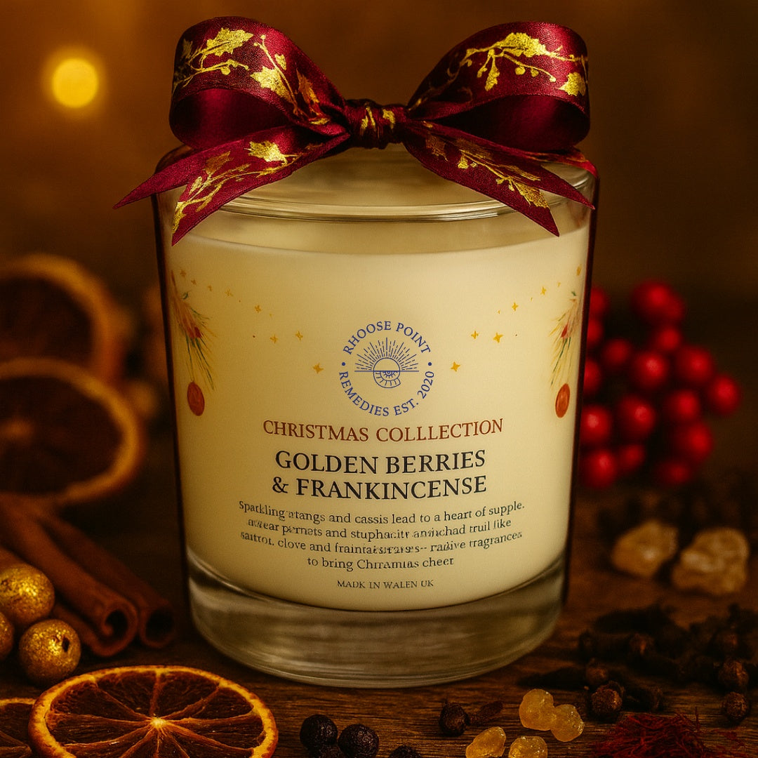 Candle labeled 'Golden Berries & Frankincense' from the Christmas Collection with a decorative bow.